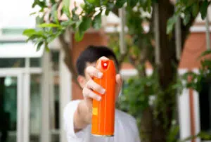 Hand holding insect spray can outdoor