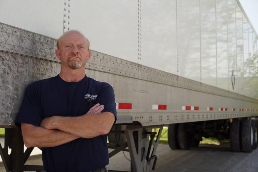 Sisbro driver leans against truck