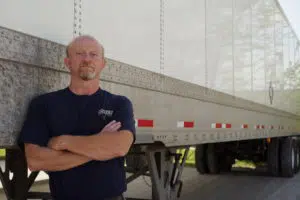Sisbro driver leans against truck