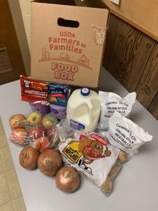 Farmers to Families food box with milk, meatballs, hotdogs, apples, cheese, yogurt, onions, and potatoes