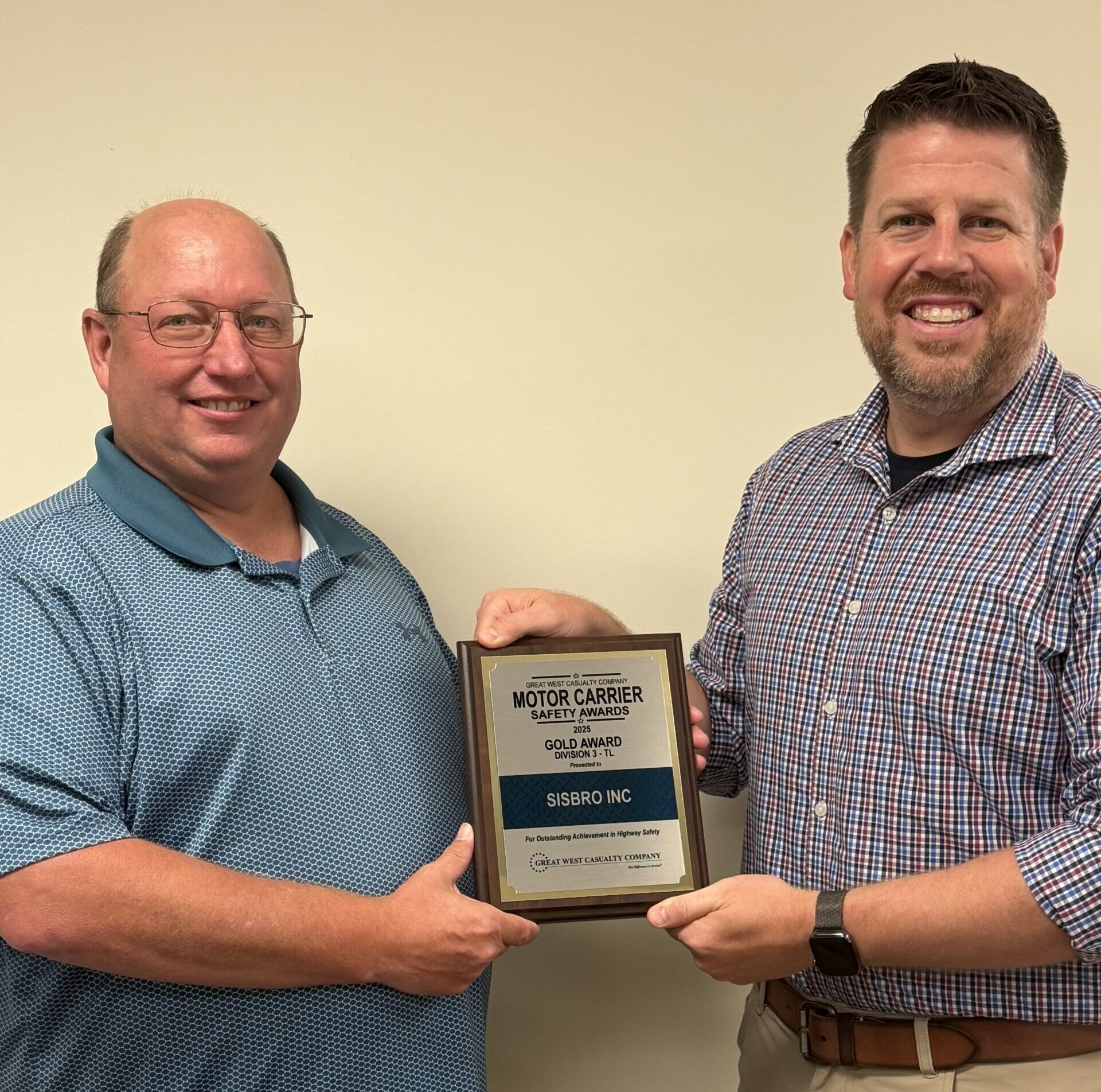 Glenn Meyers, Sisbro Director of Safety (left), and Tyler Jones (right) of Great West display Sisbro's 2025 Gold Motor Carrier Safety Award.